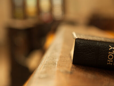 Black Bible laying on wooden table in church