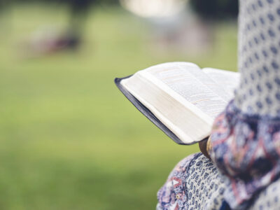 Woman reading a Bible in a park